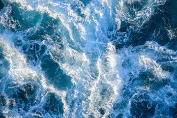 Bubbling waves with foamed backlight from the setting sun. Transparent. Navy blue. Blue. Background. Pattern.