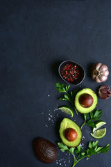 Fresh ingredients for making guacamole : avocado, garlic, lime, parsley, pepper and salt. Top view with copy space.