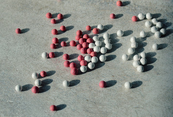  white and pink balls of powder and blush on a marble background, close up 
