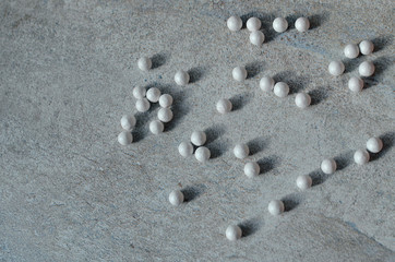 white highlighter balls on a gray marble background, close up