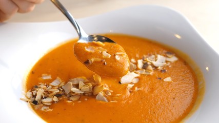 Eating Tomato Cream Soup With A Spoon. Closeup.