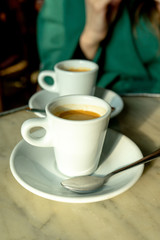 Cup of coffee in a nice hipster cafe. Soft focused image. Cup of espresso on old table of cafeteria. 