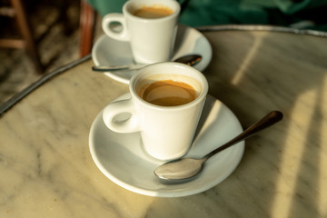 Cup of coffee in a nice hipster cafe. Soft focused image. Cup of espresso on old table of cafeteria. 
