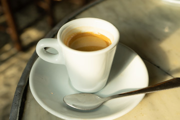 Cup of coffee in a nice hipster cafe. Soft focused image. Cup of espresso on old table of cafeteria. 