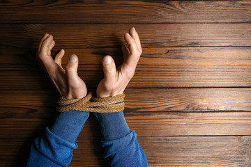 hands with a rope on a wooden background
