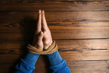 hands with a rope on a wooden background