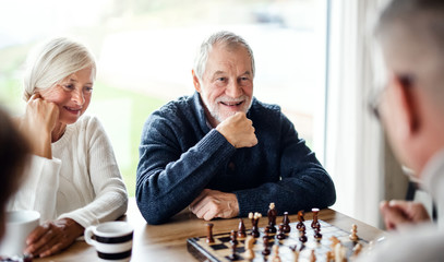 Group of senior friends at home, playing board games.