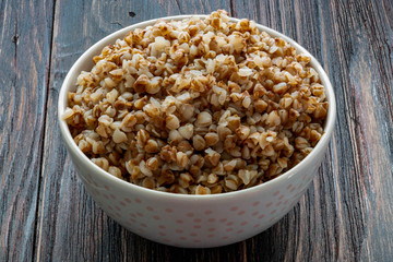 Buckwheat porridge in a ceramic bowl on a wooden table