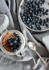 Delicious dessert: tiramisu in a glass jar and natural yogurt in a glass cup with fresh berries, strawberries and blueberries. 