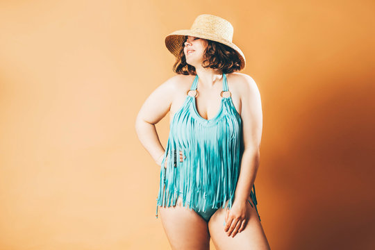 Beautiful Plus Size Model In Blue Swimsuit Posing At The Yellow Background.