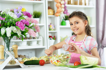 Portrait of cute little girl preparing fresh salad