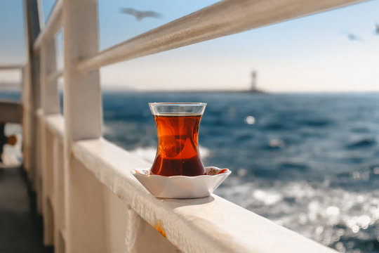Glass of turkish tea on the ferry (vapur), Bosphorus view in Istanbul, warm colours