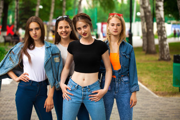 Four schoolgirls in summer park - obrazy, fototapety, plakaty