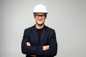 Portrait of happy young business man in helmet isolated on white background
