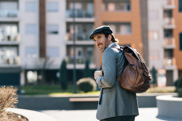 Young happy businessman walking in the city.