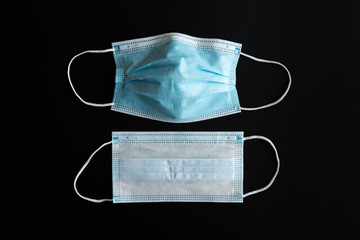 2 blue medical masks isolated on black background