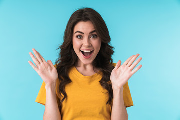Surprised young girl isolated over blue wall background.