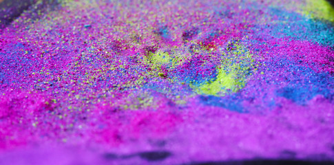 Multi-colored powder sprayed on black background. Holi celebration