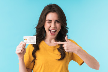 Positive smiling young pretty woman holding credit card.