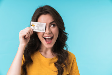 Positive smiling young pretty woman holding credit card.
