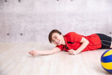 バレーボールをやる女性（笑顔でレシーブ）