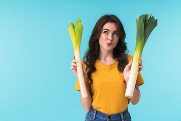 Thoughtful young girl holding leek.
