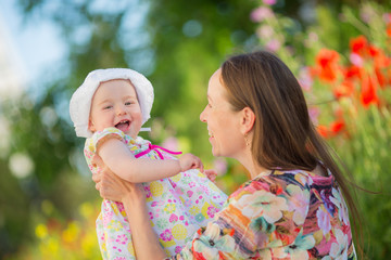 Obraz premium Happy woman and child on the poppy meadow.