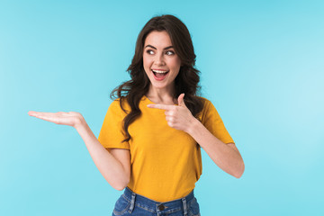 Positive young pretty woman pointing.
