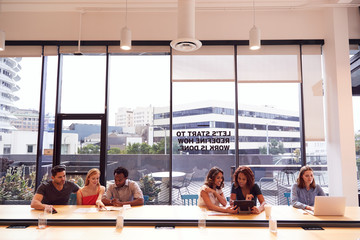 Businessmen And Businesswomen Working In Shared Open Plan Office Workspace