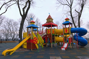 Playground for little kids in the park. An empty children's playground is waiting for children. The early foggy morning in Saint Volodymyr Hill. Kyiv, Ukraine