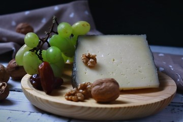 queso curado de oveja acompañado de nueces, dátiles y uva blanca.