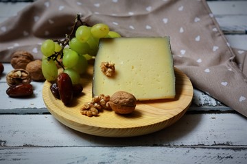 queso curado de oveja acompañado de nueces, dátiles y uva blanca.	
