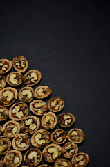 walnut halves in the lower left corner on a black background top view vertical orientation