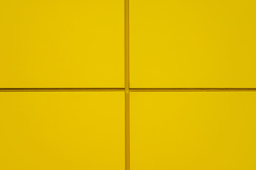 Yellow metal wall texture background. Modern building wall from metal plates. Yellow cross. Close up with copy space for design