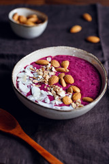 Purple berry smoothie with coconut flakes, oats and almond nuts.