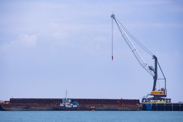 Fototapeta na wymiar 2 units of Harbor Mobile Crane (HMC) are being loaded onto barges
