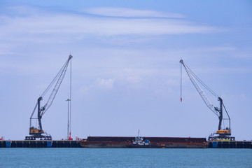 Obraz premium 2 units of Harbor Mobile Crane (HMC) are being loaded onto barges