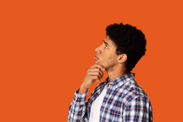 Problem solution. African-American man deep in thought on color background, side view. Blank space