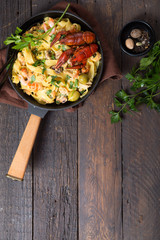 Seafood fettuccine pasta with crayfishes, octopus shrimps, on stone pan. Gourmet dish