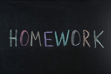 Obraz premium Word HOMEWORK written with chalk on blackboard