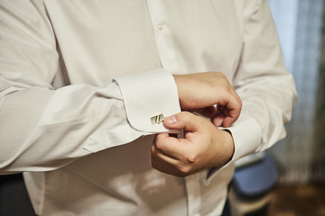 businessman dresses white shirt, male hands closeup,groom getting ready in the morning before wedding ceremony