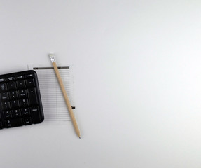  keyboard, piece of paper and pencil on a white background