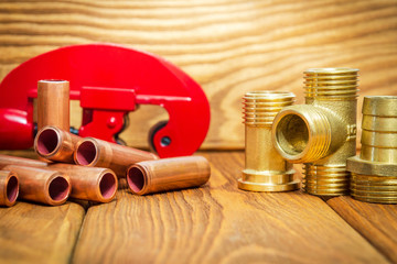Copper pipes and brass fittings with connectors for plumbing repairs on vintage boards