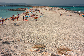 Bathers sunbathing in the wild and sunny Illetes beaches in Formentera on the Balearic islands of Spain.