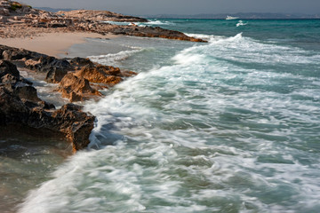 Bathers sunbathing in the wild and sunny Illetes beaches in Formentera on the Balearic islands of Spain.