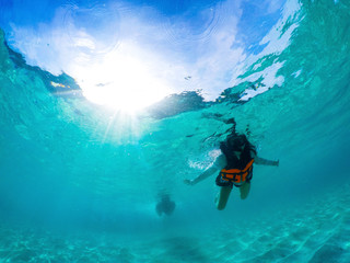 woman wearing snorkeling mask diviing under clear sea water  - obrazy, fototapety, plakaty