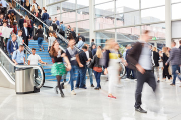 Viele Business Leute gehen auf Rolltreppe auf Messe