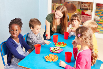 Children in kindergarten eat vegetables as a snack