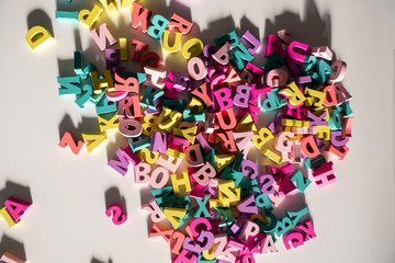 Plenty of colorful wooden letters on a White background