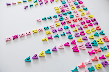 Plenty of colorful wooden letters on a White background
